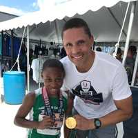 <p>Kyle Snow comparing medals with Olympian Dan O’Brien</p>
