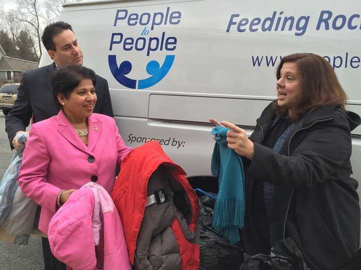 Legislators Alden H. Wolfe and Aney Paul present the coats and sweaters donated in the first Winter Coat drive last year to Diane Serratore, executive director of People to People.