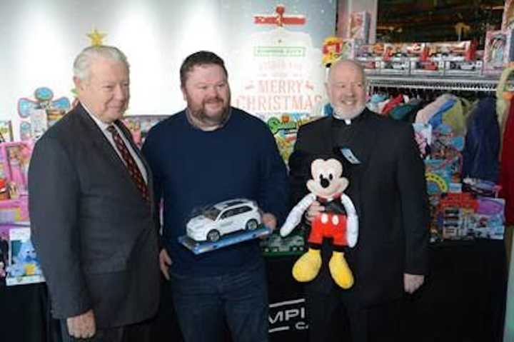 Tim Rooney (left), President &amp; CEO of Empire City Casino and Monsignor Kevin Sullivan (right), Executive Director of Catholic Charities, are joined by Josh Blake (center) of Costa Mesa, CA.
