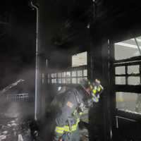 <p>A firefighter examines the damage at a Westport fire on Saturday, Jan. 4. </p>