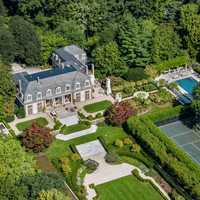 <p>The lawn features a step-down courtyard, irrigated vegetable garden, gated tennis court, and in-ground pool with pool house, among other amenities.</p>