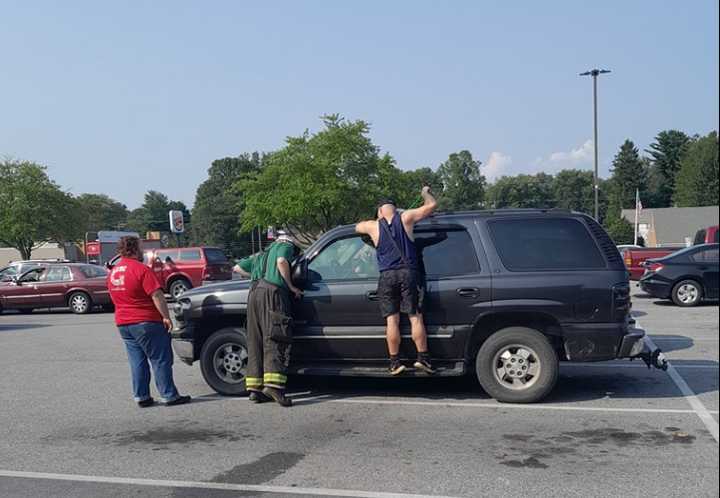 Firefighters rescuing the child from the locked car.