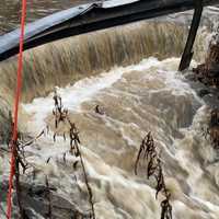 <p>An image from December 2023 shows water overtopping Route 121/116 in North Salem at the site of the blocked culvert that is to be replaced.&nbsp;</p>