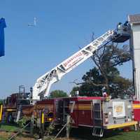 <p>Firefighters cutting out the side wall to access the rafters and free the man.&nbsp;</p>