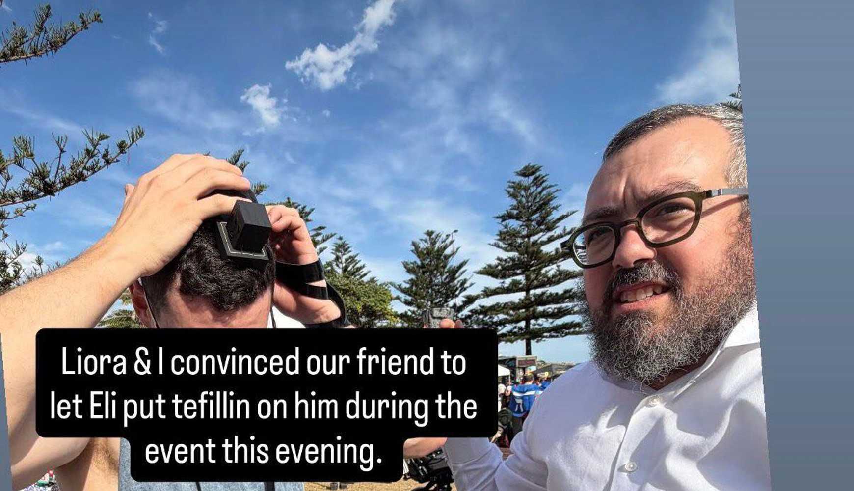 
Rabbi Schlanger helps someone wrap Tefilin prior to the attack on Bondi Beach
