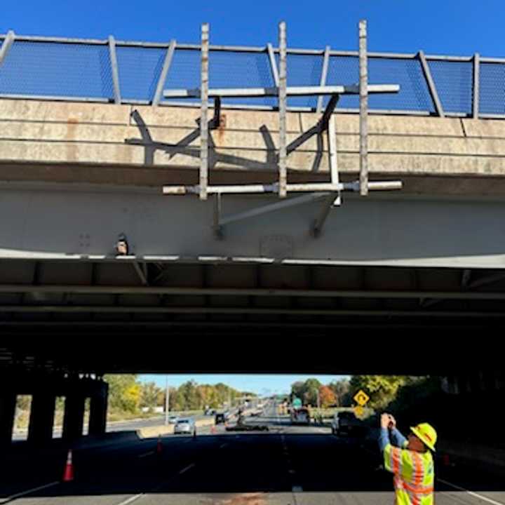 A worker inspects an I-91 overpass in Enfield after a truck hit it Thursday morning, Oct. 10.
  
