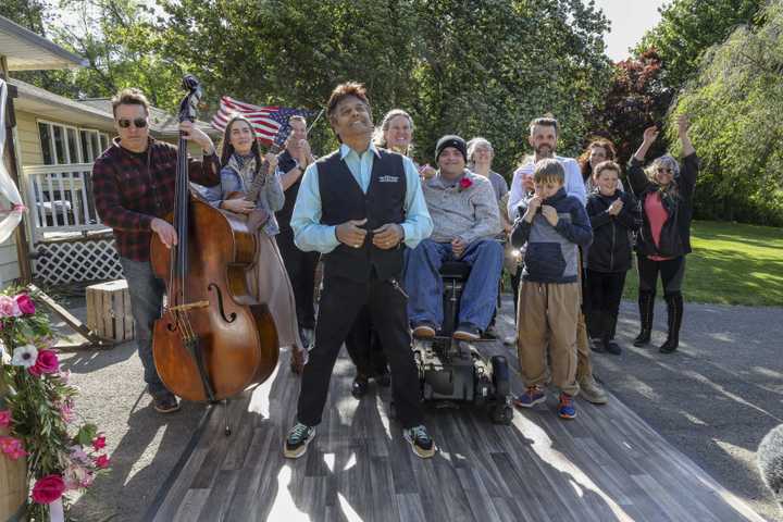 Erik Estrada, center, hosts "Divine Renovation, Destination: New England," which premieres this week and was filmed in Connecticut. Here, he celebrates with a family after crews made their home more handicap accessible and threw in a few surprises.