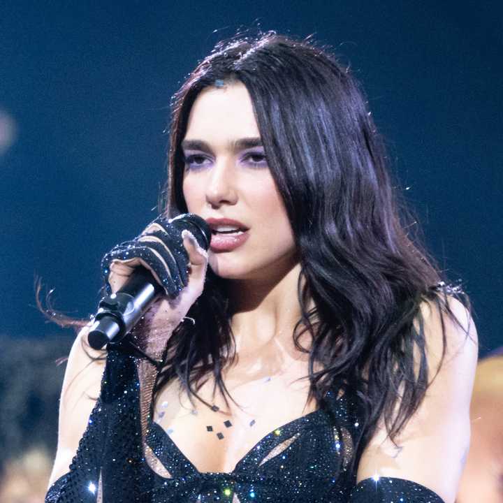 On stage, Dua Lipa showcases her signature style and powerhouse vocals during a high-energy performance.
  
