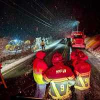 <p>Firefighters at the scene of the overturned snowplow </p>