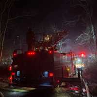 <p>Firefighter and fire engines at the scene of the double-fatal fire.</p>