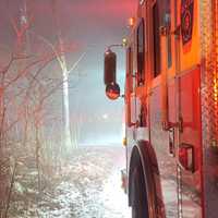 <p>A fire engine at the scene of the explosive house fire on a snowy morning.</p>