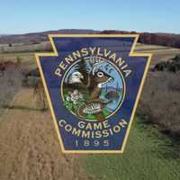 <p>The Pennsylvania Game Commission logo over a landscape photo of rural PA </p>