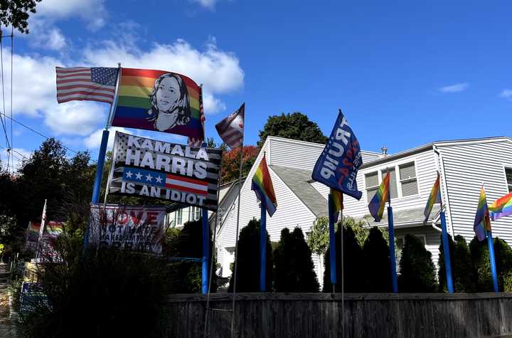 A rainbow flag with Kamala Harris' face on it hangs directly above a neighbor's flag that reads "Kamala Harris is an idiot" in Paramus.