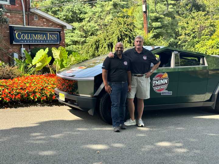 Fabio Antonio Arbelaez and Ryan McDermott with a Tesla Cybertruck outside of The Columbia Inn.&nbsp; &nbsp; &nbsp;