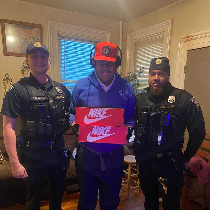 New Haven Police Officers Trevor Brown and Evans present two new pairs of shoes to an autistic man who had his sneakers stolen last month