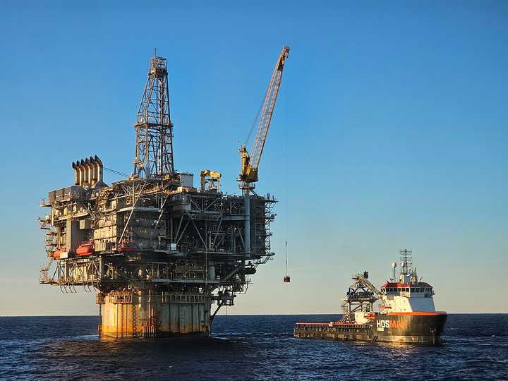 Personnel transfer being conducted between offshore oil platform Holstein and offshore supply vessel HOS Black Rock. A crane fixed to the oil platform transports crew from the oil platform onto the boat using a Billy Pugh personnel transfer basket.