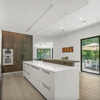 <p>An oversized ultra-modern kitchen overlooks an 800-square-foot deck and lush gardens.</p>