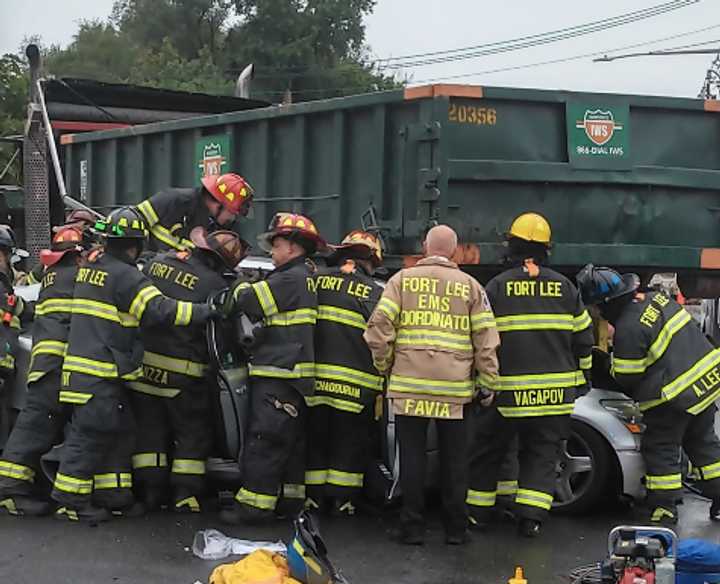 The vehicle appears to have been wedged under the construction vehicle.