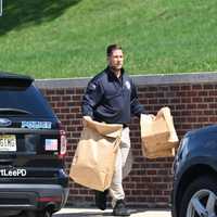 <p>Authorities remove evidence bags from the school.</p>