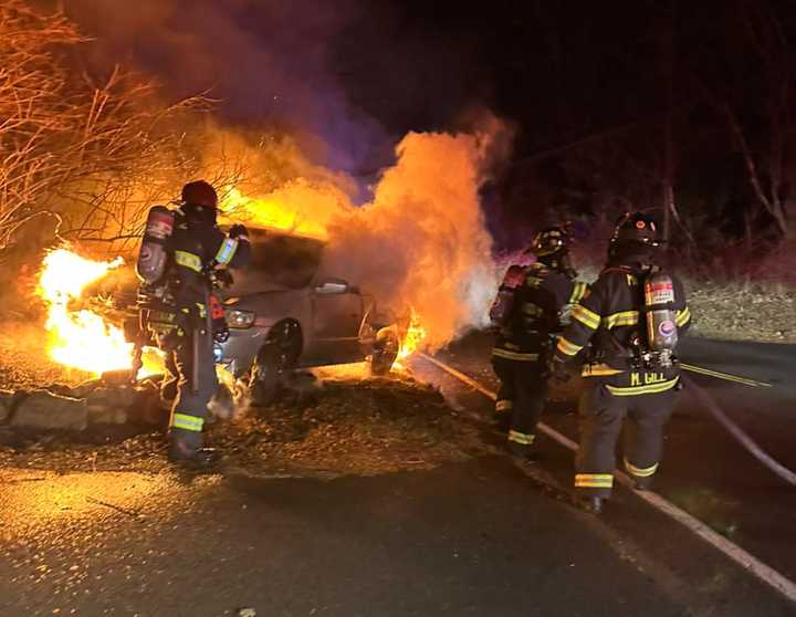 Monroe firefighters battle a car fire following a two-vehicle crash on Saturday evening.&nbsp;