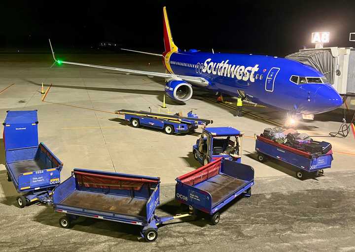 A Southwest Airlines airplane and baggage tractors at Long Island MacArthur Airport in Islip, NY, on December 30, 2023.
  
