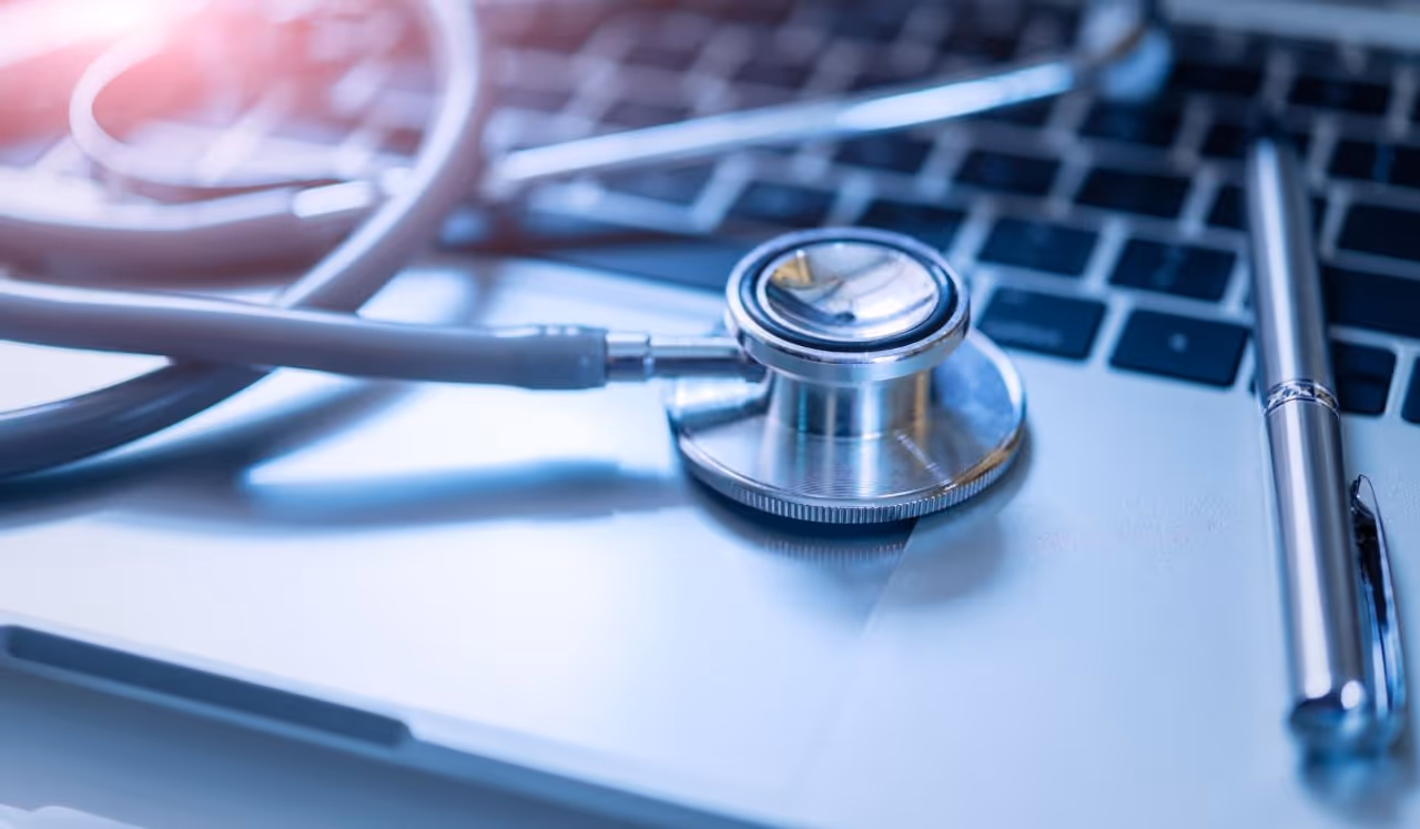 A stock photo of a stethoscope and a laptop computer.