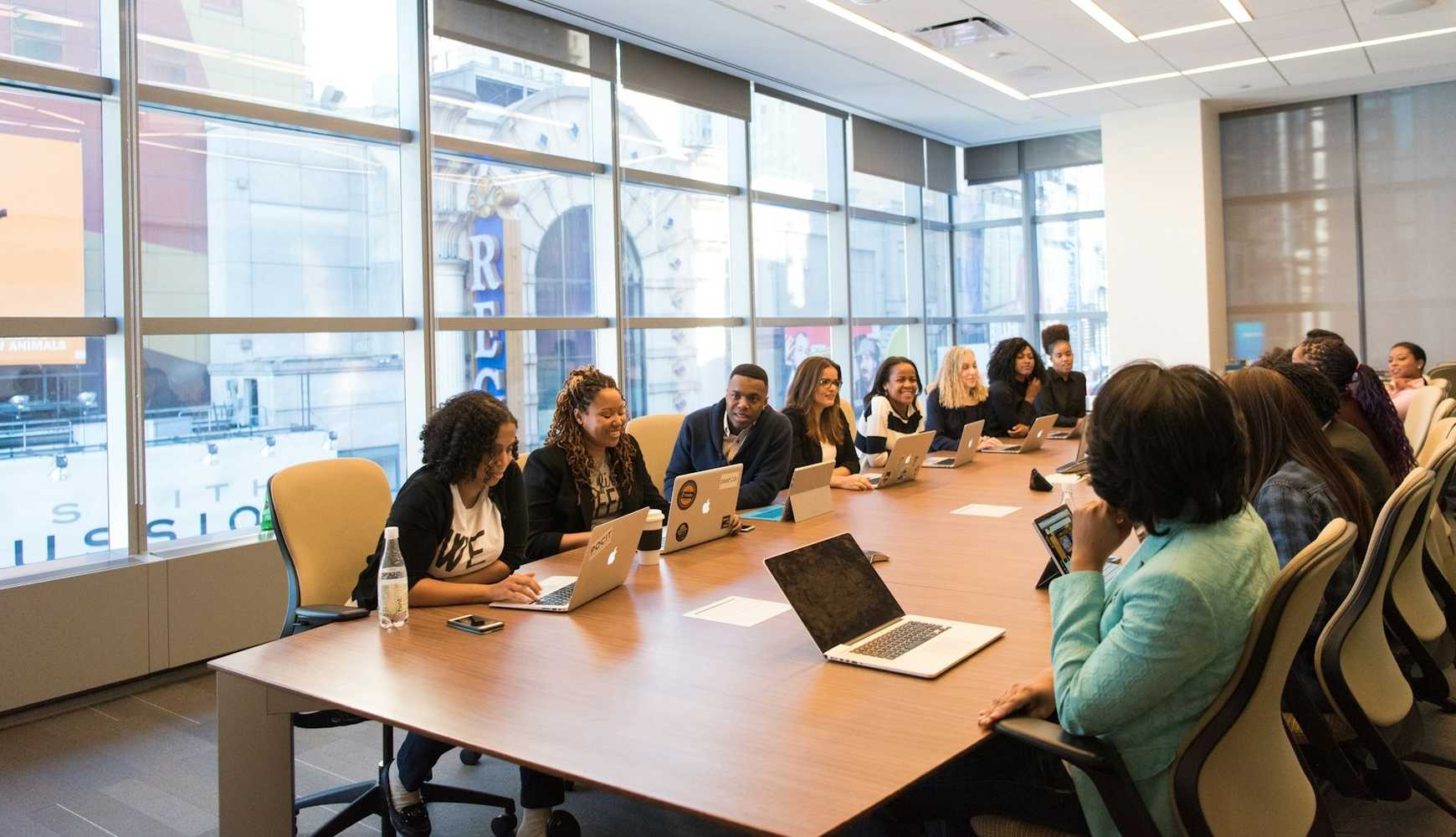 
Workers sitting around a conference room table.
