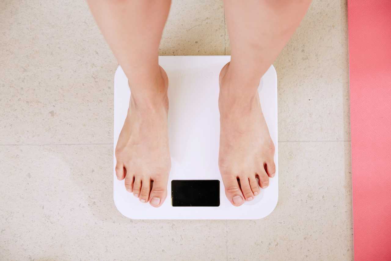 A person standing on a digital bathroom scale.