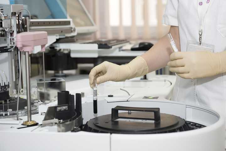 A medical laboratory worker holding test tubes.