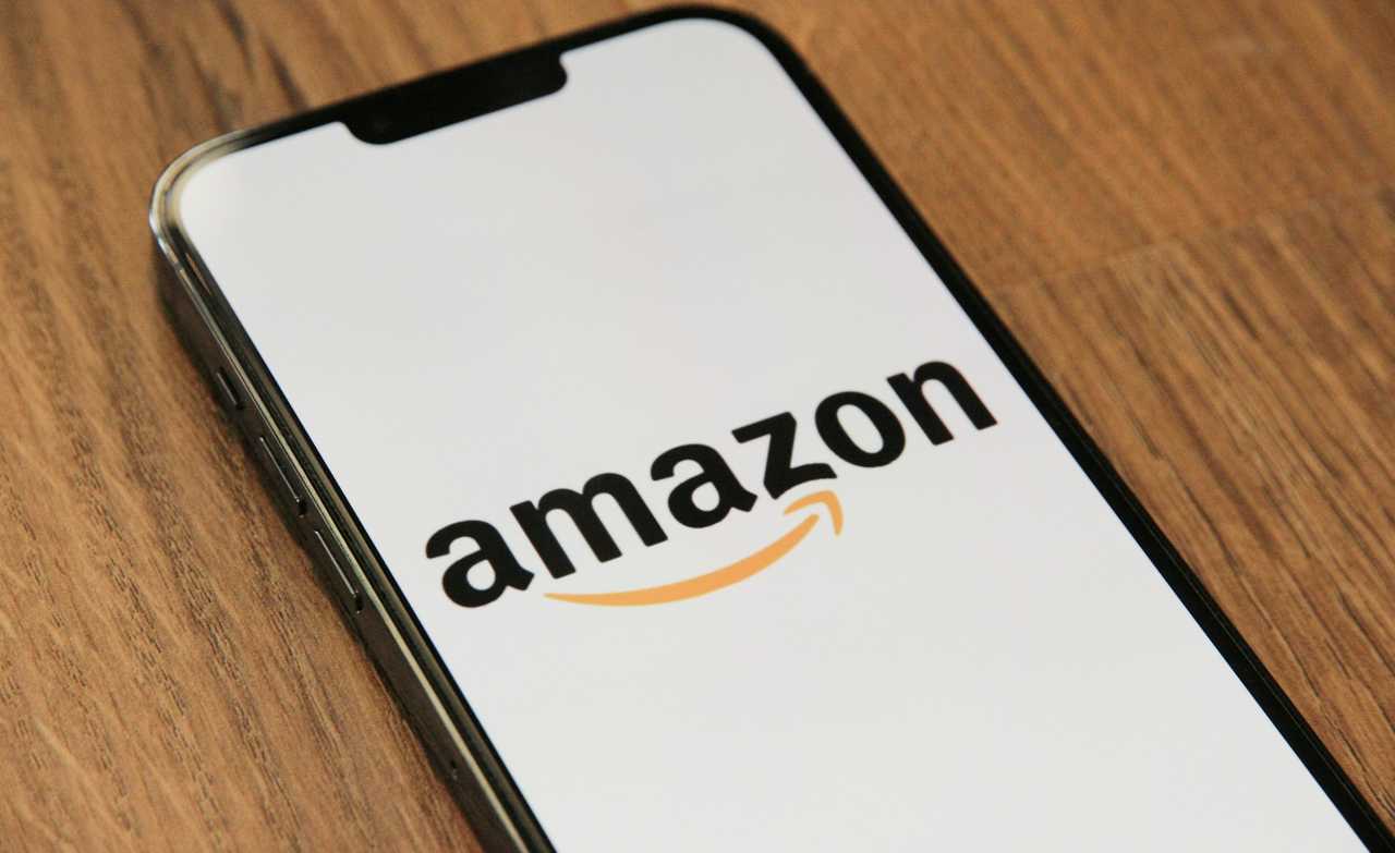 A smartphone displaying the Amazon logo. A smartphone displaying the Amazon logo.