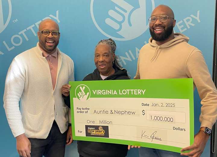 Virginia Lottery Executive Director Khalid Jones (left) presenting the million-dollar check to Geraldine Smith and Miran Smith.