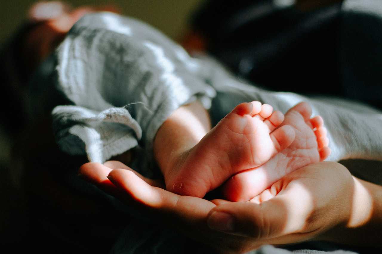 A parent holding a baby's feet.