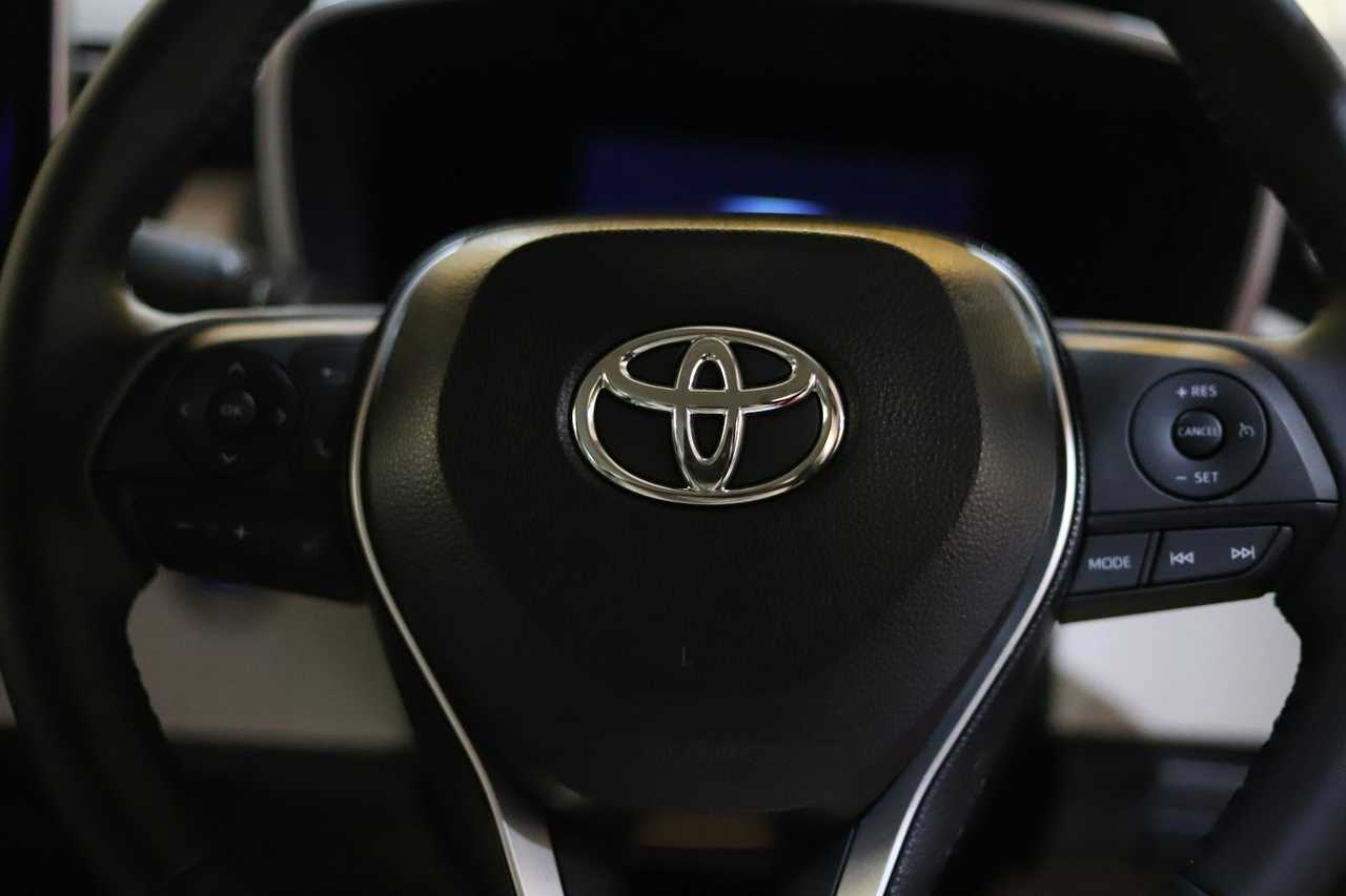 A Toyota emblem on a steering wheel. A Toyota emblem on a steering wheel.