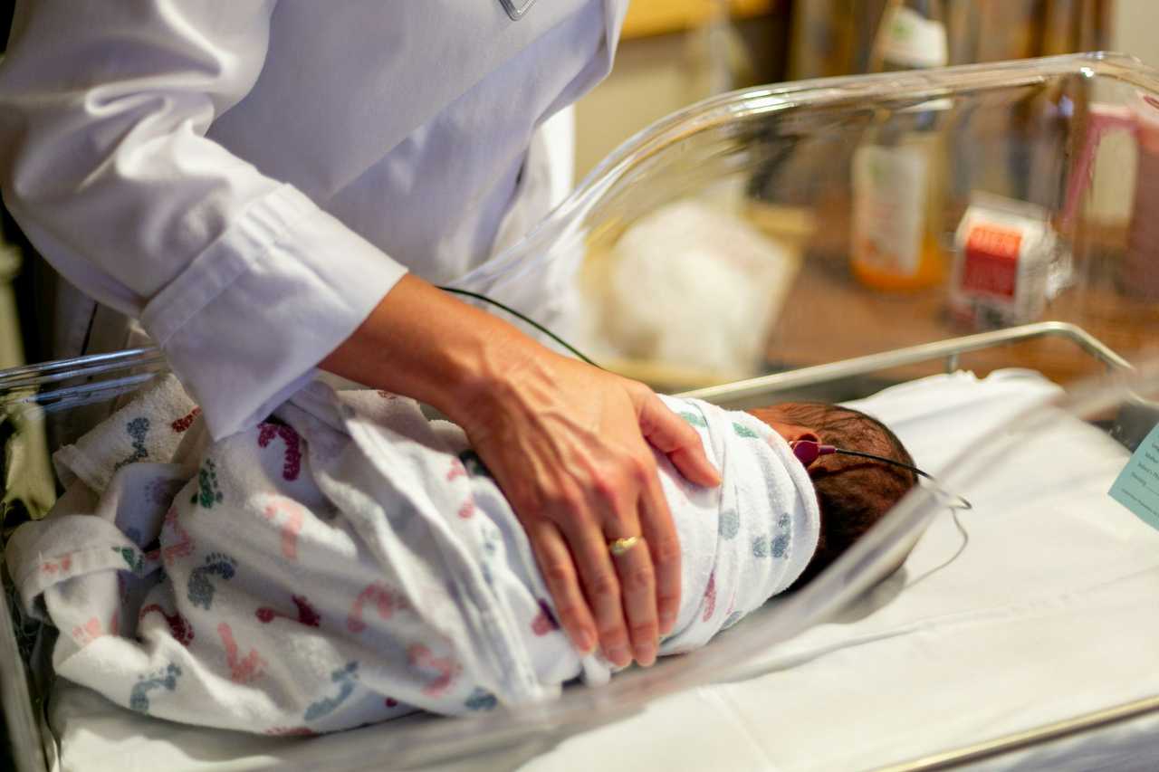A doctor conducting a hearing test on a newborn. A doctor conducting a hearing test on a newborn.