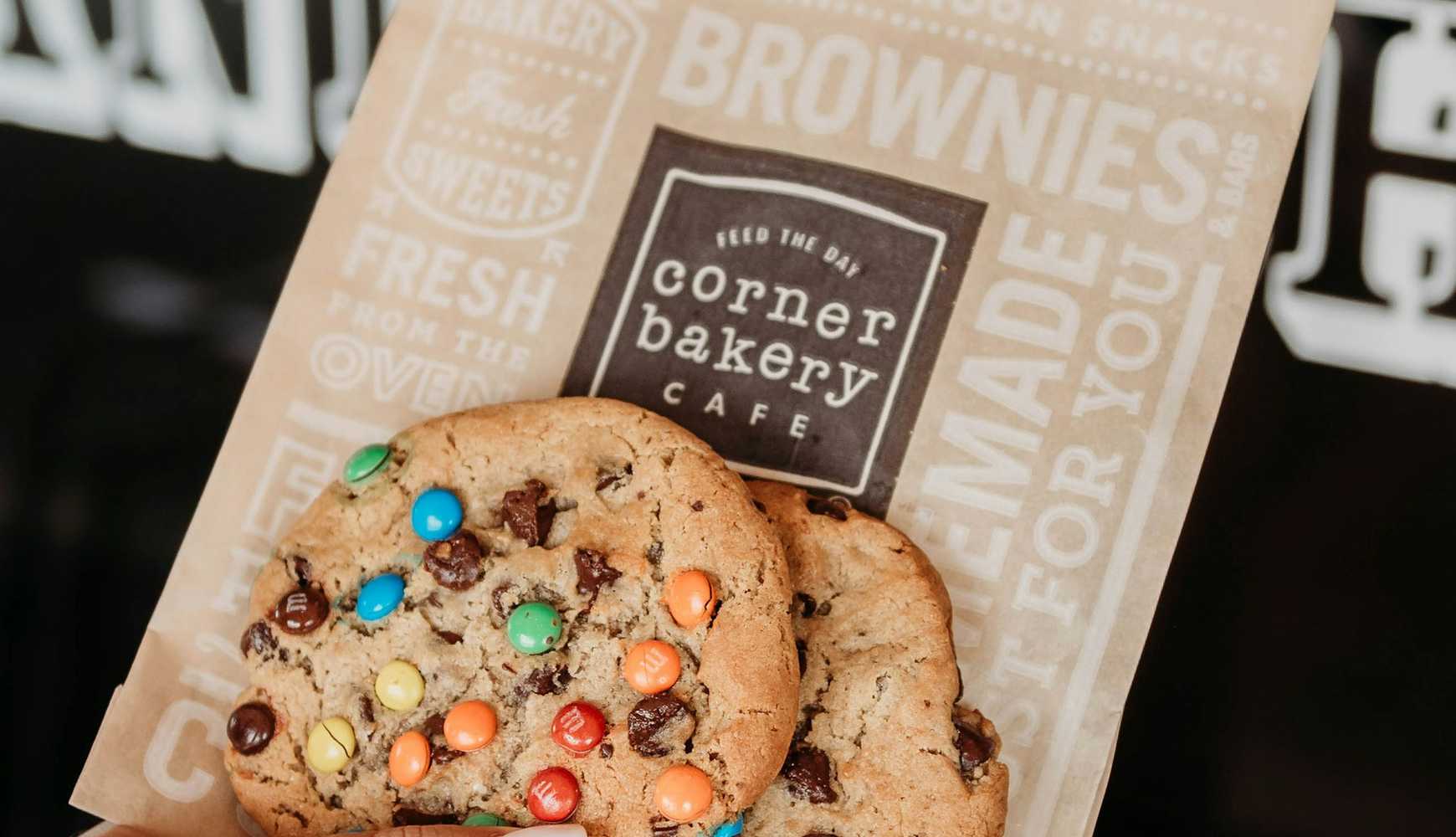 
A person holding cookies from Corner Bakery Cafe.
