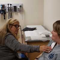 <p>Program manager Dana Dolce, APN, and Mary during a visit to JSUMC to calibrate her DBS system.
  
</p>